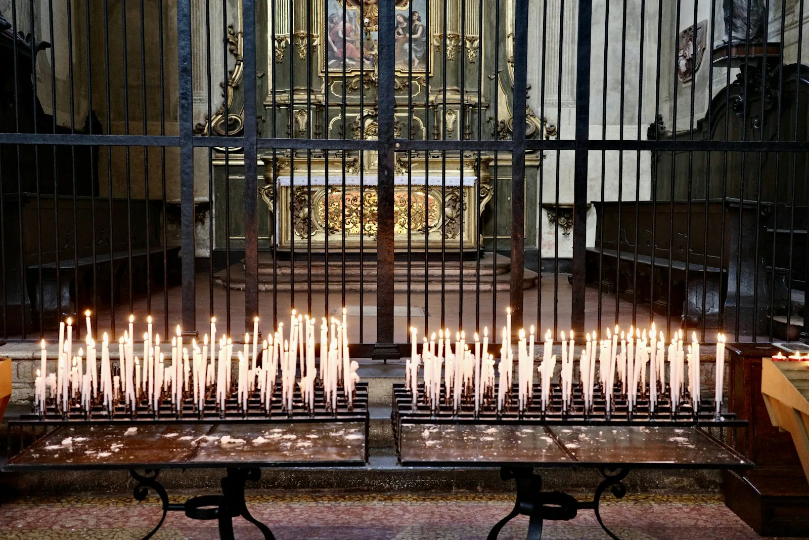 Rows of lit candles in a peaceful sanctuary, suggesting prayer and meditation